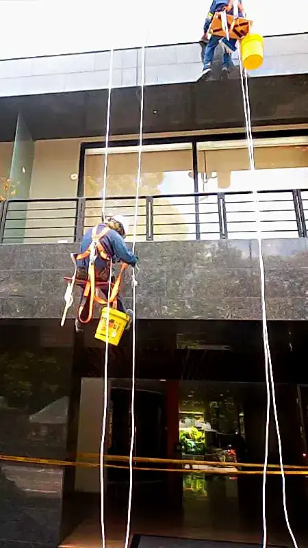 Técnicos de Limpio limpiando vidrios en altura en un edificio de Bogotá