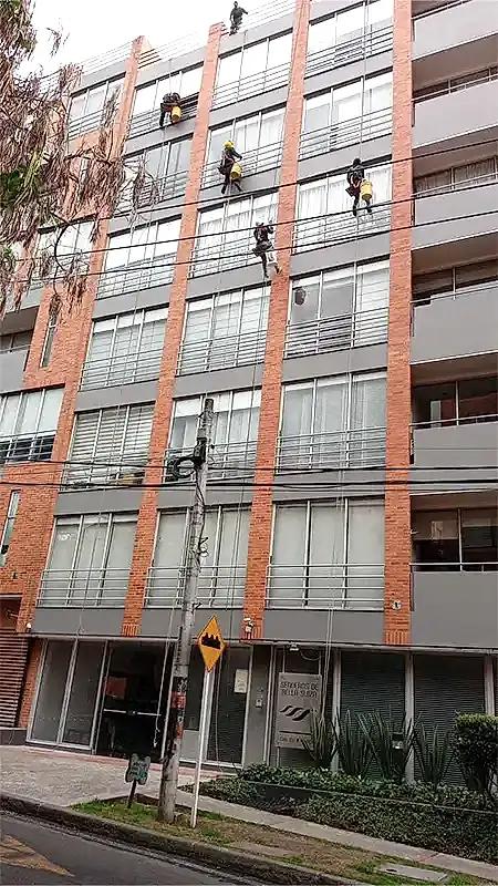 Técnicos certificados de Limpio trabajando en altura en una fachada en Bogotá