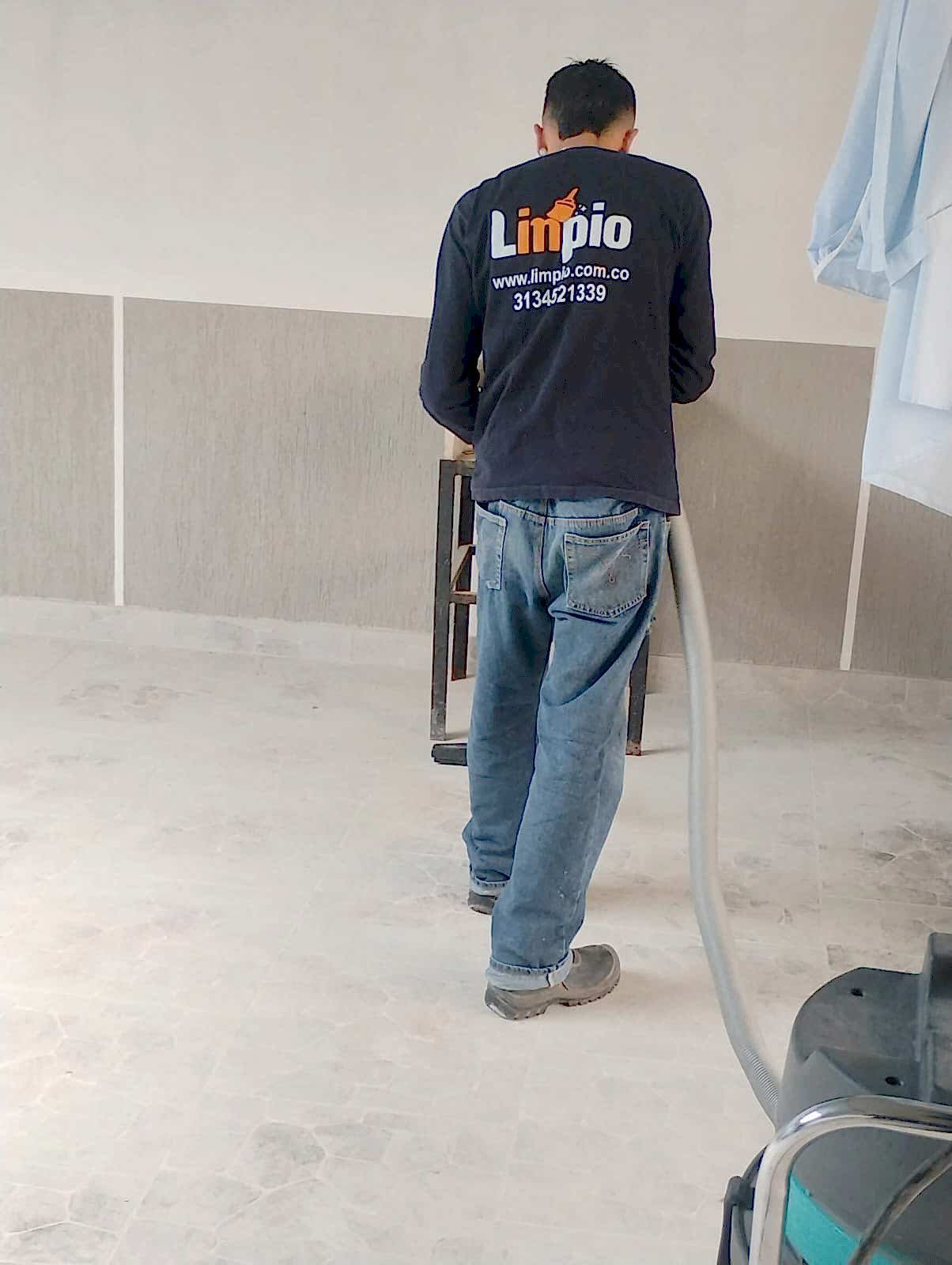 Operario uniformado de Limpio aspirando un piso con equipo industrial