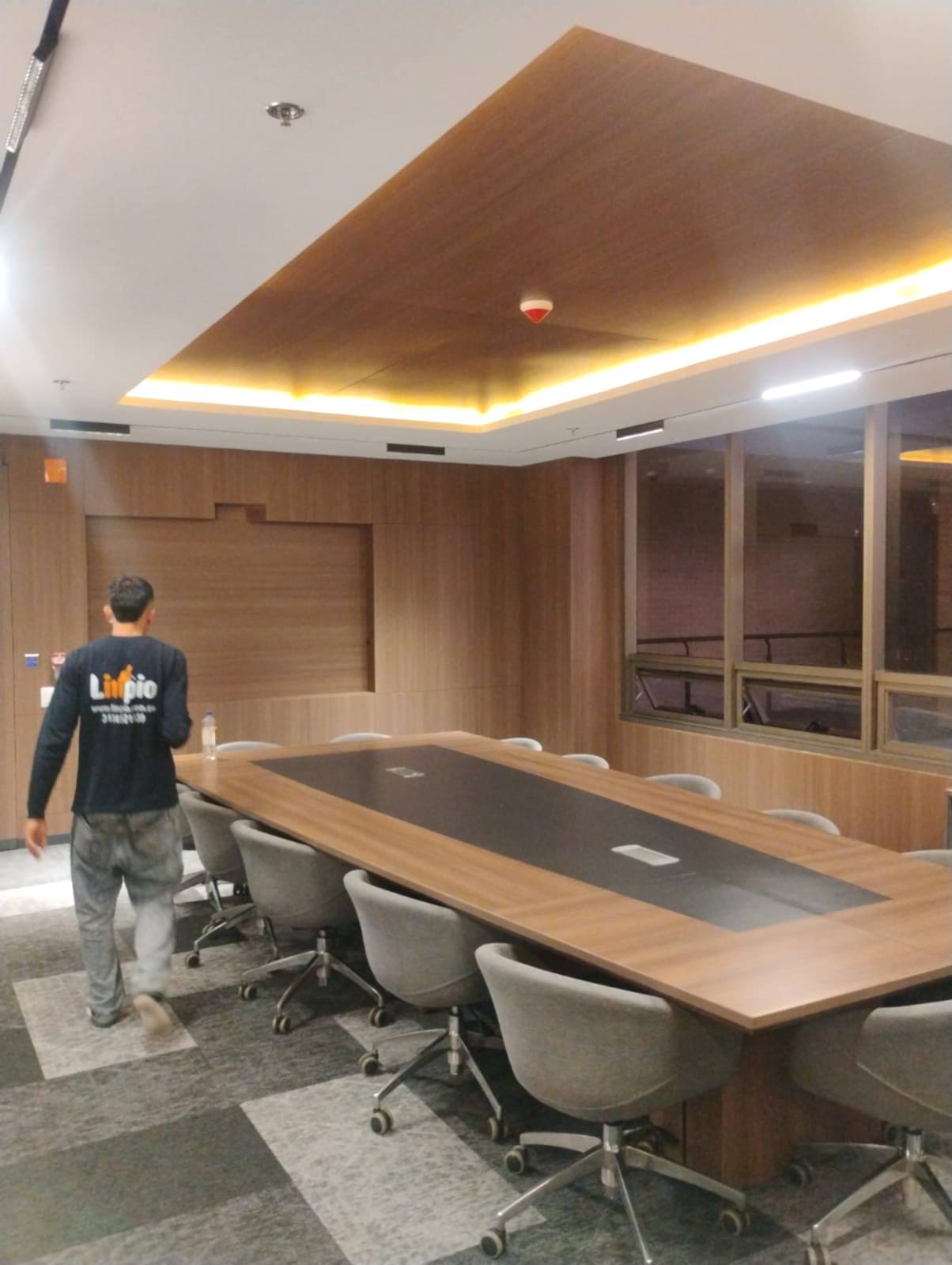 Operario de Limpio realizando limpieza en una sala de juntas corporativa